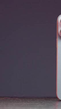 Metalik kenarlı aydınlatma ile mor arkaplan üzerinde beyaz telefon kamera modülü yakın plan