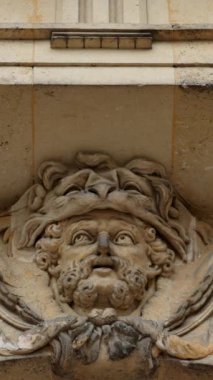 Yakın plan sakallı maskaranın anahtar taşı çelenk ve kumaşlı eskimiş kireç taşı desenli derin