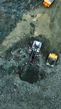 Hava platformu ve kazıcı, senkronize kazı, sondaj ve kazma sekansı ile birlikte çukurda çalışıyor.