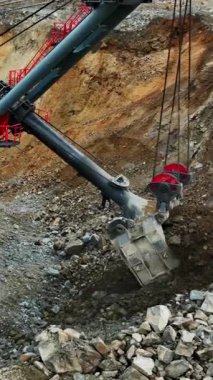 close-up of boom joints and bucket teeth, rope shovel digging rock and lifting material, grease and wear