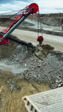 Kürek nakliye kamyonu için hassas bir yaklaşım sergiliyor, kamyon yatağının üzerine konmuş kova, sürücü yüklemeye hazırlanıyor.,