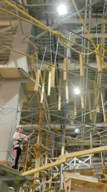 Kapalı bir macera parkında zorlu bir köprüde gezinen maceraperest kadın odaklanma ve kararlılık gösteriyor. Yaratıcı