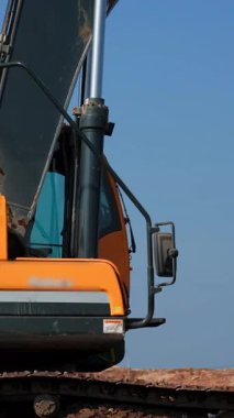 Sarı kazıcı kolunu inşaat alanında hareket ettiriyor. Kırp