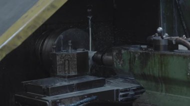 Koyu renk atölye metal torna kesiciler, yatağa tutturulmuş çelik bloklar soğutma spreyi ve ince cips parçaları. Medya