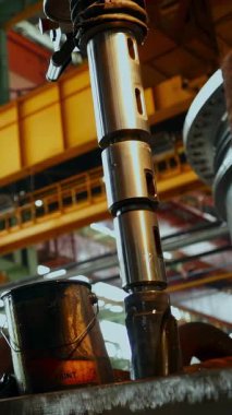 Ağır sanayi ortamında büyük bir makine çalıştıran fabrika işçisi.