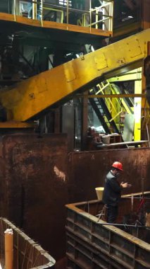 Metalürji işçileri dökümhaneye erimiş metal döküyorlar.