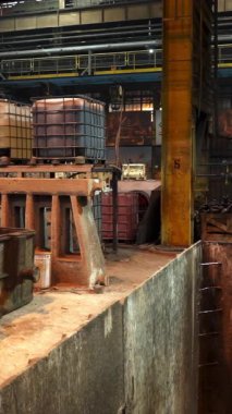 Erimiş metal, bir dökümhanede endüstriyel vinçle taşınıyor.