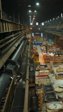 Geceleri faaliyet gösteren büyük bir endüstriyel üretim tesisinin genel görünümü