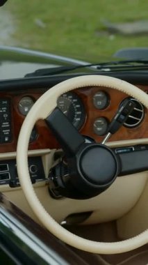 Klasik üstü açılır araba içi. Krem rengi deri koltuklar ve ahşap süslemeler. Lüks ve klasik stili ön plana çıkarıyor.