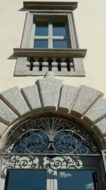 Kemerli girişi ve işlenmiş demir kapısı olan zarif bir binanın mimari ayrıntıları.