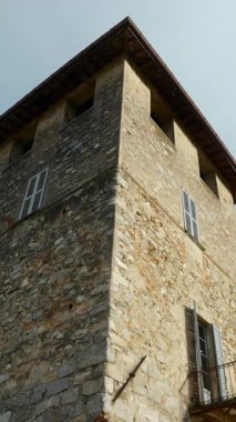 Bulutlu mavi gökyüzüne karşı antik bir binanın heybetli taş kulesi