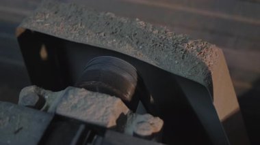 Yıpranmış konveyör tekerleği toz altında döner. Rusty Bearing ve Monting Parantez Üretim Hattı 'na yakın çekim. Medya