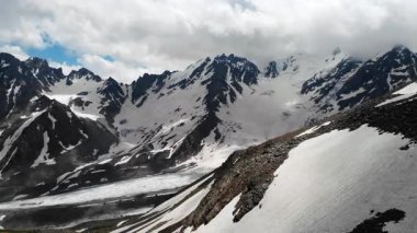 Geniş Kar Tarlası ve Jagged Peaks Panoramik Görünümü Süpüren Buzul Dili ve Karışık Altında Rocky yamaçlarını gösteriyor. Medya