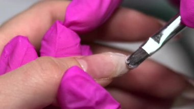 Yakından bakınca, eldivenli teknisyen seviyeleri akrilik iken çivili metal serpinti ile pürüzsüz bir yüzey. Medya