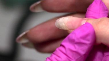 Yakından İnce boncuklar takan ve düzleştiren Eldiven Teknisyenini gösteren Tırnak Uzantısı Yapıcı Jel. Medya