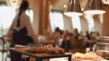 Window 'un yanında hareket eden sunucusu olan kaplama büfe tramvayı, Lively Bistro iç mekanı, önlüklü garson. Medya