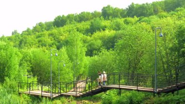İki Refakatçi Tepedeki Kaldırımda Duraklıyor Yeşil Vadi 'nin Sessiz Paylaşılan Anı Çerçeveletti. Kırp
