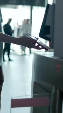 Yoğun bir ulaşım merkezindeki turnikelerden geçmek için akıllı telefon teknolojisini kullanan yolcular. Medya