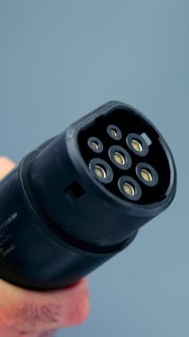 Elektrikli araç şarj cihazını şarj noktasına bağlayan bir tamirciye yaklaş ve sürdürülebilir ulaşımı teşvik et. Medya