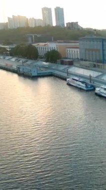 Çok sayıda yolcu gemisi, günbatımında modern bir şehrin beton setine yanaşıyor. Kırp