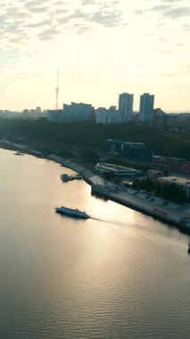Nehir trafiği şafak vakti Dnipro nehrinde, şehir siluetini ve manzaralı su yolunu gösteriyor. Kırp