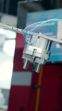 Beyaz robotik kol endüstriyel ortamda tekrarlanan hareketler yapıyor. Medya