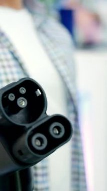 Elektrikli araç şarj aletinin uygun kullanımını gösteren bir mühendisin fotoğrafını çek. Medya