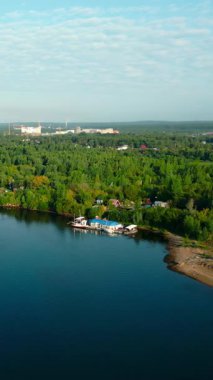 Sakin nehir, gün doğumunda berrak mavi gökyüzünün altındaki şehir manzarasını yansıtıyor. Kırp