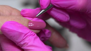Yakın plan Tırnak Teknisyeni Beyaz Müşteriler El, Pembemsi Eldiven 'de Tırnak ve Polonyalı Çalışması Yapıyor. Medya