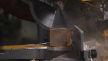 Operatör Eller kereste bloğunu testere testeresi, talaş kıvılcımları ve dinamik bıçak hareketi ile kesiyor. Medya