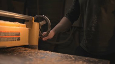 Yakın plan El Planer Wheel, Sarı Endüstriyel Makine, Masaya Saçılmış Talaşlar, Teknisyen Ayarlama. Medya