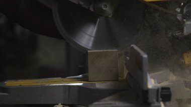 Operatör Eller kereste bloğunu testere testeresi, talaş kıvılcımları ve dinamik bıçak hareketi ile kesiyor. Medya