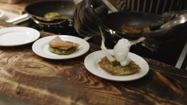 Haşlanmış haşlanmış yumurta ve siyah eldivenli kaşık kremalı sos. Altın patatesli haşlanmış patates. Medya