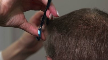 Crown and Nape 'de yakın çekim makaslı kısa saç kesimi berber silueti hassas parçalar ve tarak ile şekillendiriyor. Medya