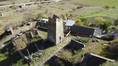 Gürcistan 'ın kırsal kesimindeki bir dağ köyünde ortaçağ taşından bir savunma kulesinin yörüngesindeki hava görüntüleri. Medya