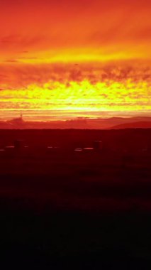 Güneşin doğuşu sisli bir dağ sırasına ve engin karanlık bir vadiye ılık bir ışık saçıyor. Medya