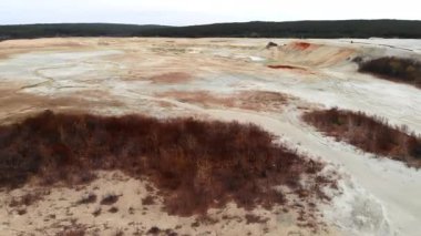 Solgun Clay ve Bulutlu Gökyüzü Altındaki Dağlık Tepeler ile Issız Kum Çukuru manzarası, Yavaş Drone. Medya