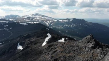 Rocky Summit Tepesi Dramatik Bulutların Altında, Dağınık Kar Topraklı Dağlık Dağ Panoraması, Keskin. Medya