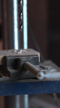 Matkap pres makinesinin kapanması atölyenin içindeki metal bir bileşende delik açar. Medya