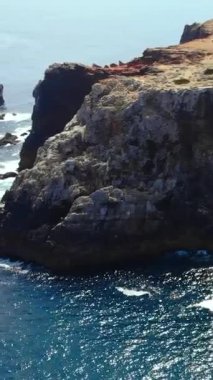 Yürüme yolu olan bir uçurum ve aşağıdaki dalgalanan dalgalar, engebeli çıkıntı, sahil geçidi ve görüş açısı,