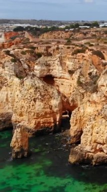 Turkuaz havuzlu dramatik kıyı kemerleri, oyulmuş mağaraların ve kemerlerin hava görüntüleri.