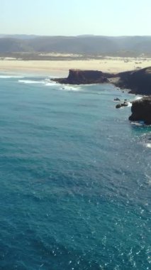 Işıldayan mavi suyu ve uzak kumlu körfezi, engebeli uçurumları, dolambaçlı yolları olan kayalık burunlar.