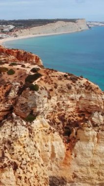 Derin mavi okyanusa bakan kızıl kayalıklar, güneşli burunların geniş havadan süpürülmesi ve dolambaçlı yollar, uzak