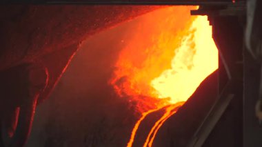 Erimiş çeliği akışkan yola döküyor, parlak turuncu çağlayanlar ve kıvılcımlar yoğun ısı sisi ve endüstriyel. Borsa klipsi