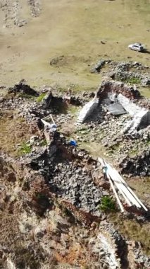 İnsansız hava aracı, Kafkasya 'daki uzak, güneşli bir dağ yamacındaki antik taş kalıntılarından uçarak uzaklaşıyor. Medya