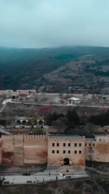 Hava görüntüleri, sisli ve bulutlu bir günde tepedeki antik naryn kala kalesini gösteriyor. Medya
