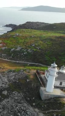 Kıyı şeridindeki Punta Robaleira 'daki beyaz deniz fenerinden uzaklaşan hava görüntüleri. Medya