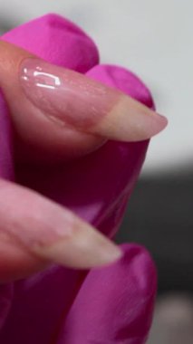 Pembe Eldivenli Teknisyen, Dikkatli Yumuşatma 'dan Yakından Beyaz Çivi Alıcı Jel Kaplama Katmanları. Medya