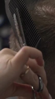 Taraklı, makaslı, saç kesimli, makaslı, saç kesimli, makaslı beyaz bir erkek. Medya