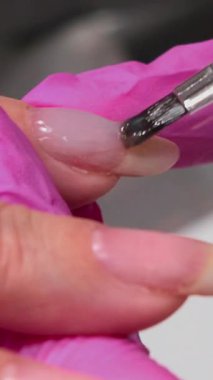 Yakından Çivi Geliştirme Pembe Eldivenler İnşa Edici Jel, Nazikçe parmak ucuna baskı. Medya